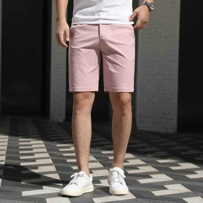 Man wearing casual loose pink men's summer pants with elastic waistband and white sneakers standing on checkered floor