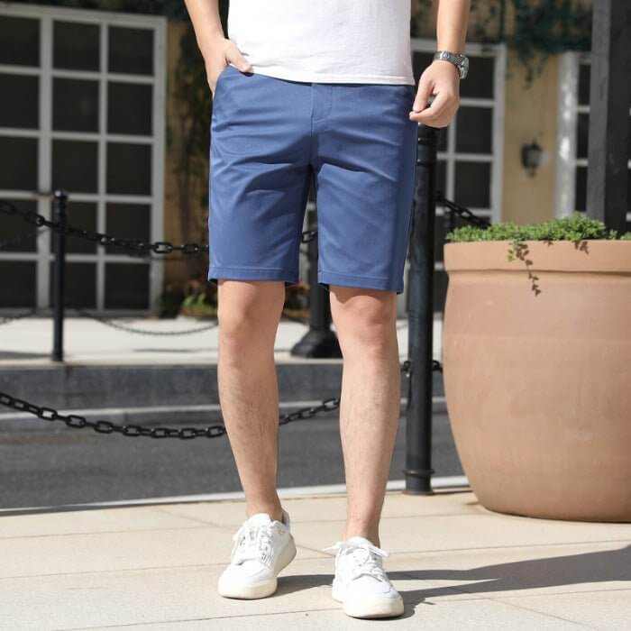 Man wearing casual blue men's summer pants with elastic waistband and white sneakers outdoors