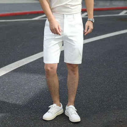 Men's white summer pants with a casual fit and elastic waistband worn with white sneakers on asphalt road
