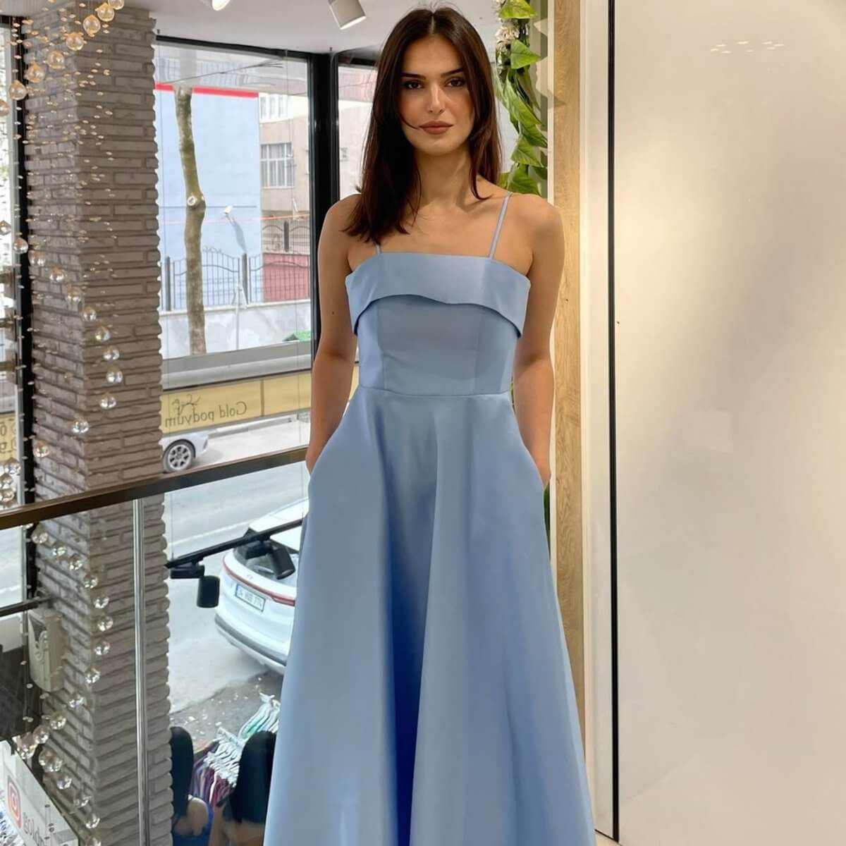 Woman wearing elegant solid color sleeveless backless tube top maxi summer dress in light blue