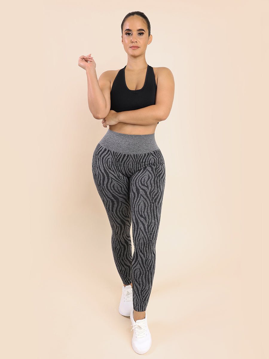 a woman in a black top and grey patterned leggings