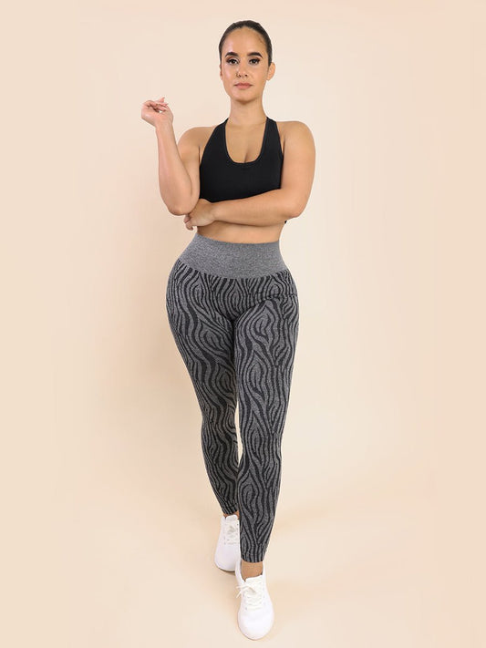 a woman in a black top and grey patterned leggings