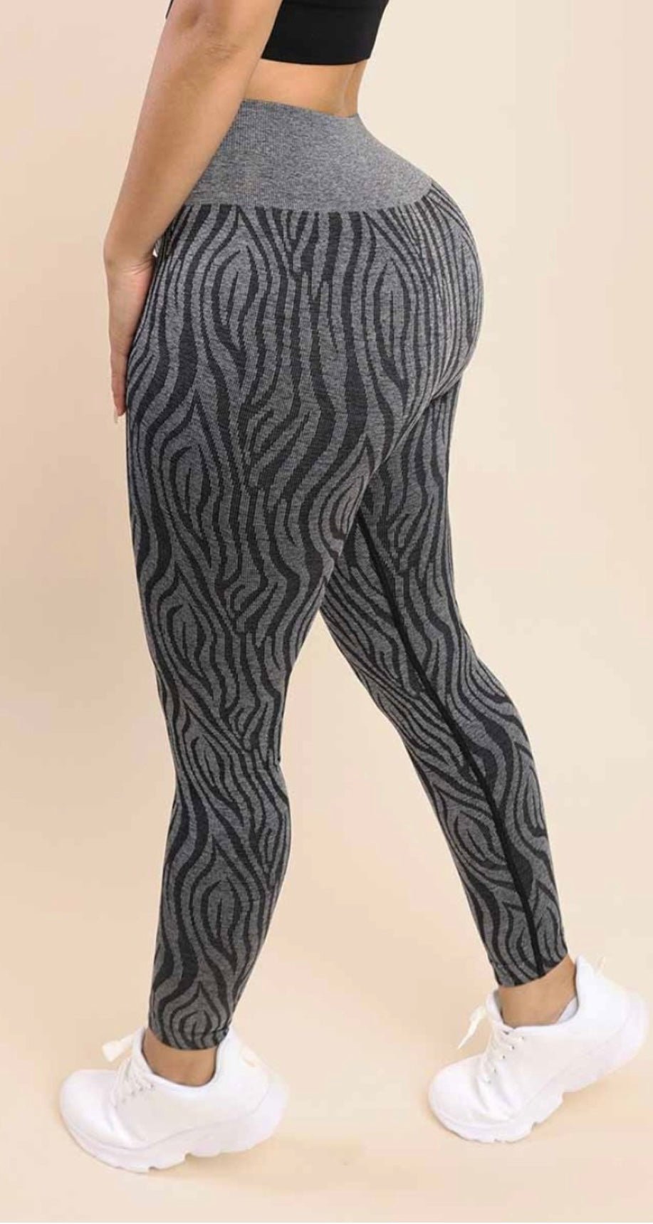 a woman in a black top and grey zebra print leggings