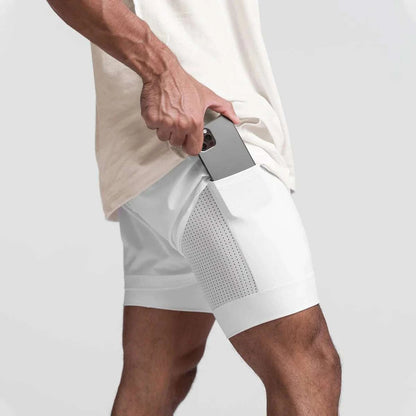 Men wearing white breathable 2 in 1 fitness gym shorts with towel loop and mesh inner tights placing phone in side pocket