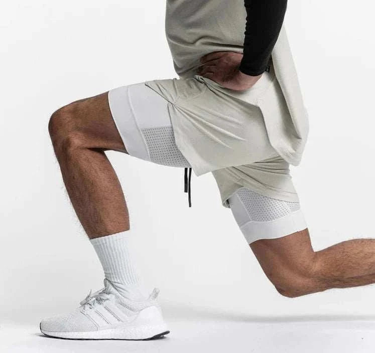 Men wearing 2 in 1 fitness gym shorts with breathable mesh inner tights and towel loop in white while stretching