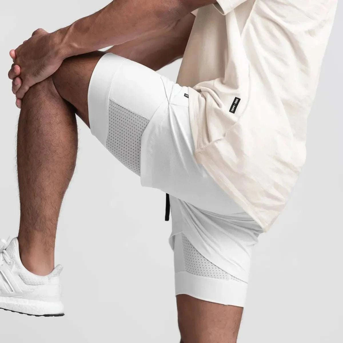 Men wearing white breathable 2 in 1 fitness gym shorts with towel loop stretching leg