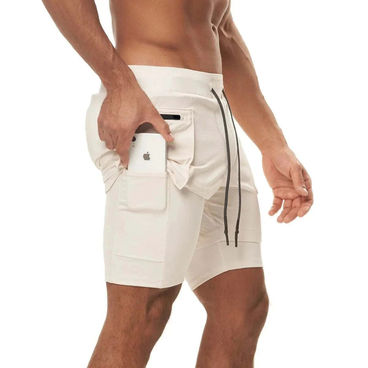 Men wearing beige 2 in 1 running training joggers with built-in shorts and a phone pocket holding a smartphone.